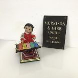 A 1950s/60s musical toy of a Young Girl playing a Xylophone, with wind up mechanism, some losses