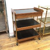 A mid century teak serving trolley, the removeable tray top above a single frieze drawer, fitted