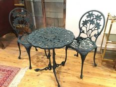 An anodised metal green painted three piece patio set including scalloped table of pierced leaf