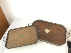 An oak drinks tray, with central metal shield shaped plaque, with gallery and handles to side, on