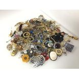 A large assortment of costume jewellery including paste and glass badges, of various forms including