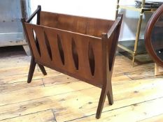A stylish 1960s/70s teak V shaped magazine rack with pierced oval front, raised on splay square