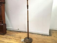 A 1920s floor lamp, the turned stem with stylised palmette knop, on circular dished base, on bun
