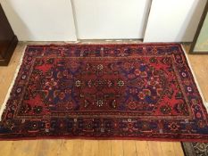 A hand knotted Hamadan rug, the red field with stylised interwoven flowers highlighted in blues