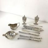 An assortment of silver including a quaich, a milk jug, pepperettes (combined: 219.39g) and butter