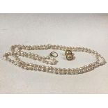 A 9ct gold crossover ring set cultured pearl (1g), a strand of baroque cultured Chinese pearls and a