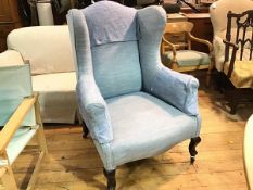 An Edwardian mahogany framed wing easy chair with upholstered panel back, arms and seat, in blue