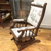 A 19thc walnut American style rocker chair, with upholstered panel back, arms and seat, with studded
