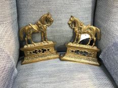 A pair of Edwardian brass chimney ornaments in the form of saddled horses on plinths, with classical