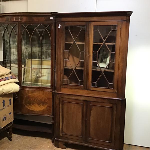 A 19thc two part corner cabinet, the cornice above a pair of glazed astragal panelled doors, with