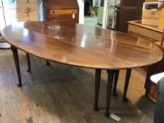 A reproduction elm oval drop leaf wake table, raised on turned supports and pad feet (76cm x 236cm x