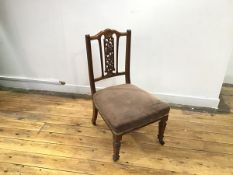 An Edwardian nursing chair, the crest with central rosette over pierced floral splat, with an