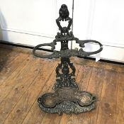 A Victorian cast iron stick stand complete with original drip tray, cast with mask, floral and