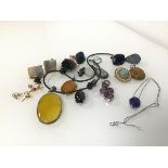 An assortment of polished stone pendants including amethyst and lapis lazuli, some mounted in
