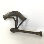 An African ceremonial axe with incised curved blade and detail of figure masks to each side, on a