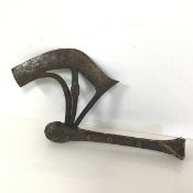 An African ceremonial axe with incised curved blade and detail of figure masks to each side, on a