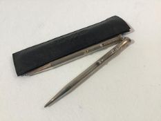 A leather pouch containing two silver yard o lead propelling pencils with engine turned