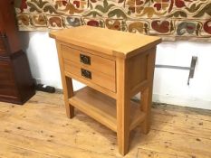 An oak side table with plain rectangular top over a single drawer with two vertical hanging