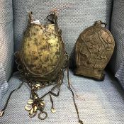 A Benin brass hanging pouch, decorated with snakes and with hanging cowrie tassles (29cm x 22cm)