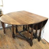 An oval gateleg drop table dining table, the top with moulded edge raised on turned baluster