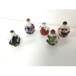 A group of Chinese snuff bottles, four decorated with birds and branches, one with monkeys, complete