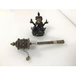 A hand held Tibetan prayer wheel with alternating red and blue stones (21cm x 4cm) and a seated