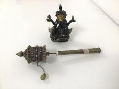 A hand held Tibetan prayer wheel with alternating red and blue stones (21cm x 4cm) and a seated