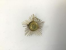 A 14 karat coin in a sunburst mount (5cm x 5cm) (12.3g)