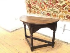 A late 17thc oak Credence style table, the semi eliptical top with iron fixings above a carved