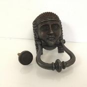 A patinated metal door knocker in the form of an Egyptian pharoah (19cm x 10cm)