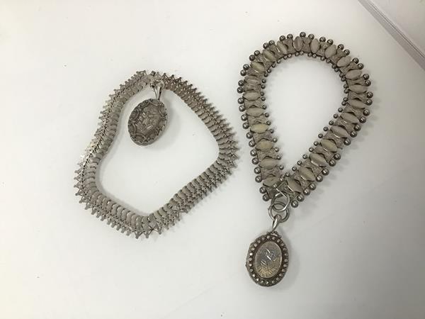 Two Victorian white metal fancy link collars, both with oval shaped lockets, with foliate decoration