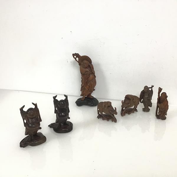 A collection of carved wooden Chinese figures, including a Buddha holding Fruit (18cm x 9cm x