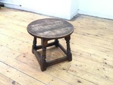 A 1920s oak occasional table, the circular top on square frame, on turned supports and box