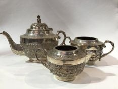 An Indian white metal three piece tea service comprising teapot with domed figure riding an