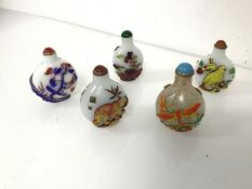 A group of Chinese snuff bottles, three with birds and branches, one with bears and one with