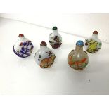 A group of Chinese snuff bottles, three with birds and branches, one with bears and one with