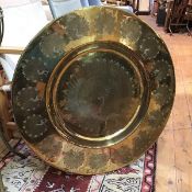 A large Indian brass dish with a central engraved peacock surrounded by a multiple peacock border (