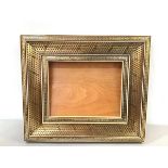 A souvenir Indian hardwood frame mounted with bone and brass studded floral border (inside: 13cm x