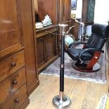 A black textured and chrome mounted dumb valet with scrolling trouser arm, centre dish and coat rack