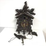 A Swiss or German cuckoo clock with bird crest and leaf decoration (a/f) (h.55cm x 33cm x 20cm)