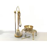 A brass three piece companion stand in the Arts & Crafts style with egg shaped handles and Eastern