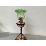 An Arts & Crafts style wrought iron copper oil well and circular base mounted oil lamp with green to
