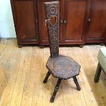 An Edwardian oak spinning chair, the tapering back with rosettes and pierced heart, with octagonal