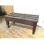 An Estate made stained pine luggage rack, the rectangular slatted top raised on square block
