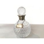 A crystal golf ball style dimpled decanter with silver mounted collar and ball pattern faceted