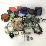 An assortment of costume jewellery including a wooden entwined bead necklace, other polished stone