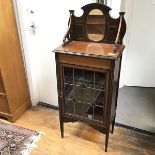 An Edwardian mahogany cabinet, with mirrored raised superstructure above a glazed door with leaded