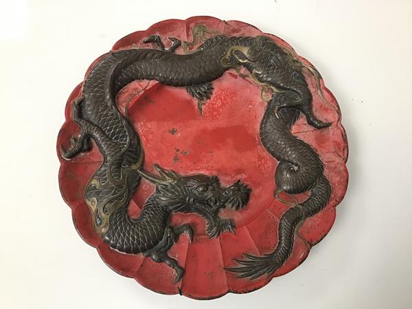 An early 20thc Japanese dish, with bronze dragon on red ground, with scalloped edge (d.30cm)