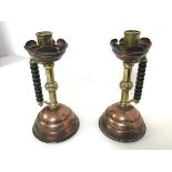 A pair of Edwardian Christopher Dresser inspired candlestick holders, with copper drip tray, on