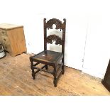 An Edwardian oak carved hall chair with twin relief carved splats and shaped wood seat, raised on
